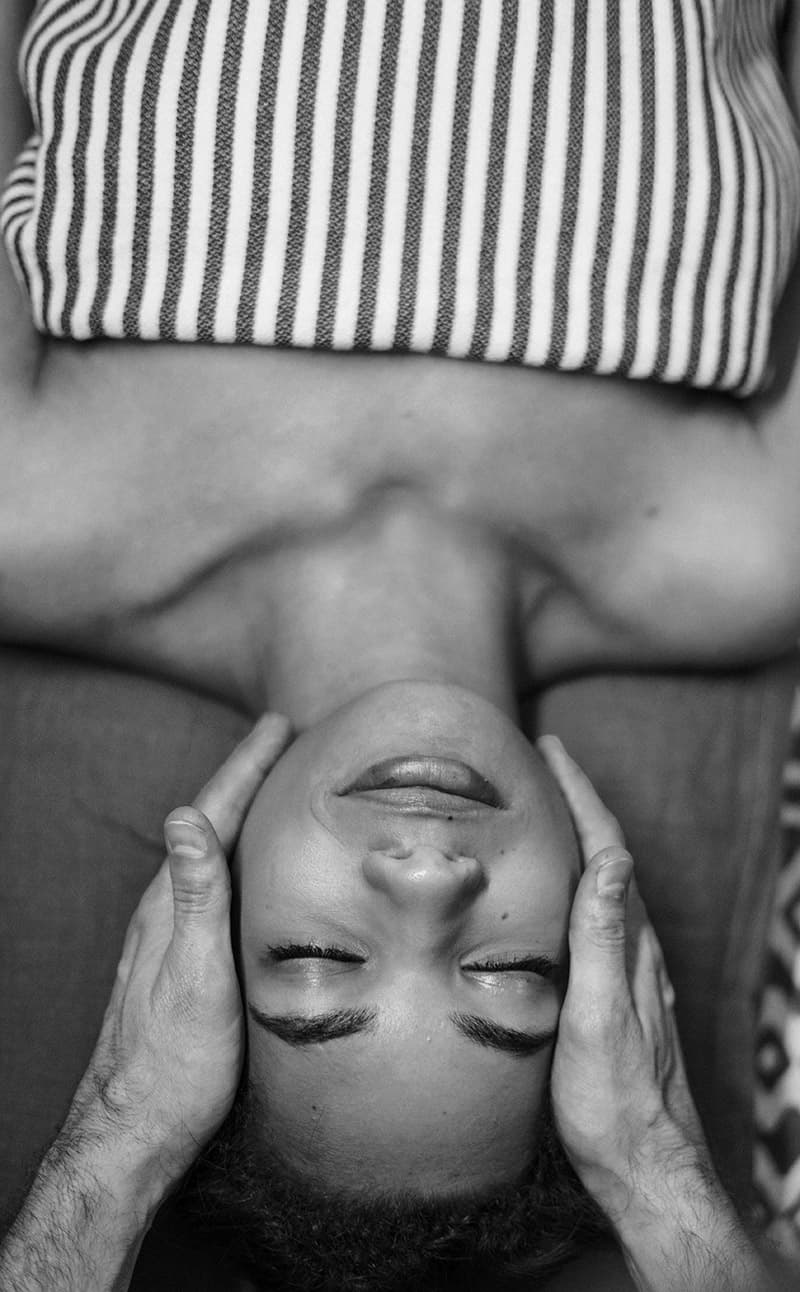 Des mains massants un visage féminin.