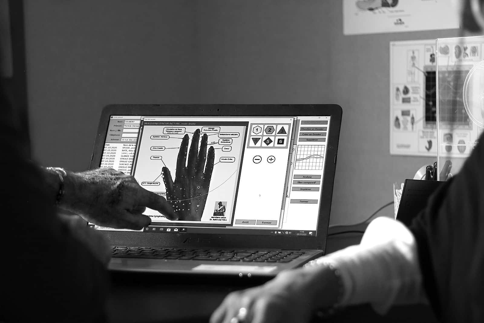 Didier Martin, du cabinet Tangan, donne une séance de Physioscan. Il montre des résultats sur l'ordinateur.